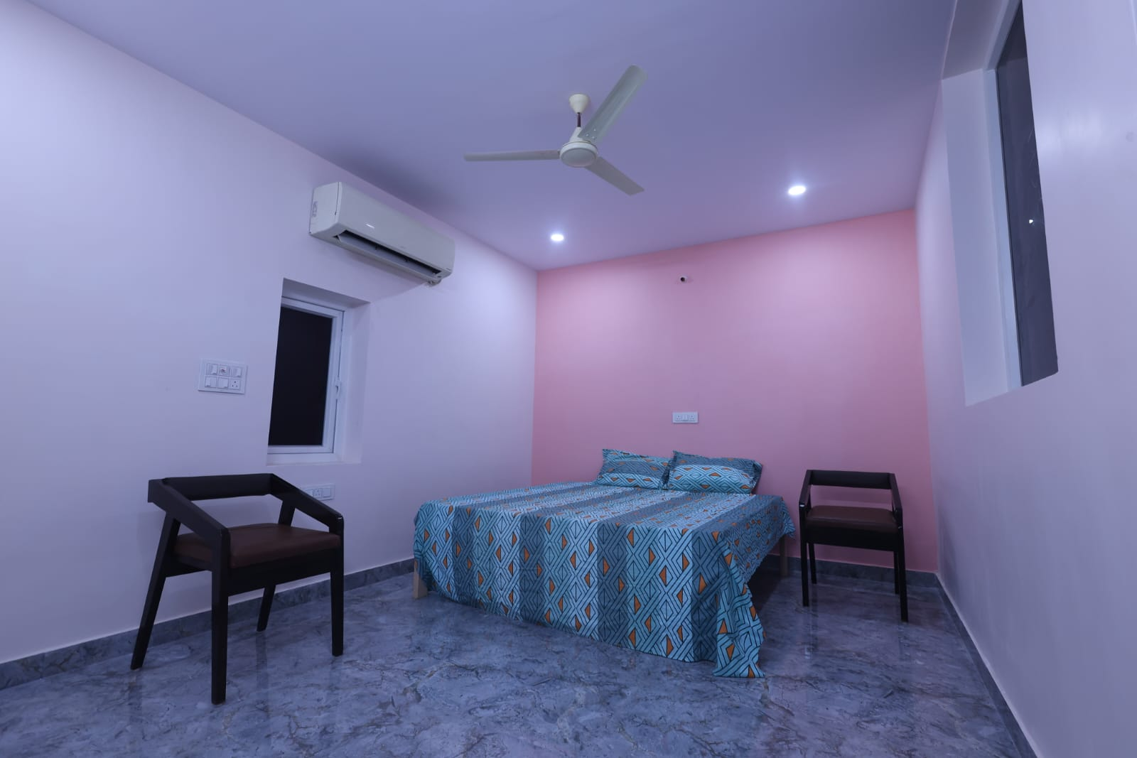 Guest room with pink accent wall and double bed