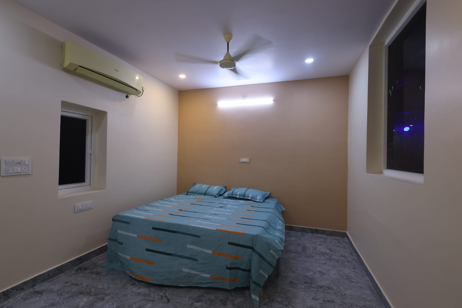 Guest room with beige accent wall and double bed